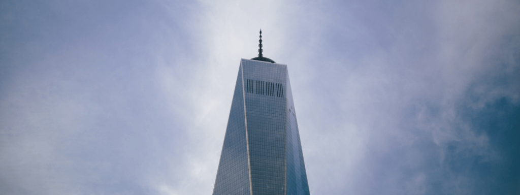 Looking up to the top of One World Trade Center on a partly cloudy day