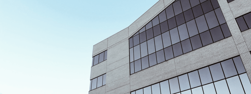 A mixed brick and glass building against a light blue sky